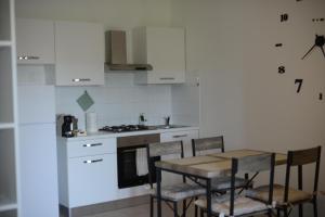 a kitchen with a table and a stove and white cabinets at La Fenice Suite in Perugia +22 photos