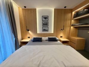 a bedroom with a large bed with two desks at Appartamento Rododendro in Andalo