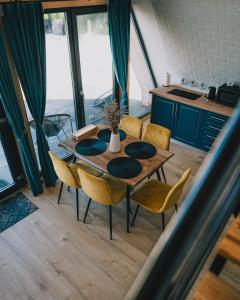 a table and chairs in a room with a kitchen at A-frame Marisa Vadu Crisului in Vadul lui Carol II