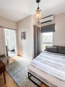 a bedroom with a large bed and a chandelier at The 4M Favorite House - Stunning & Spotless 2-Bed Apt (#3) in Ann Arbor