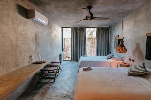 a bedroom with two beds and a window at Dos Mares Barefoot Luxury in El Cuyo +50 photos