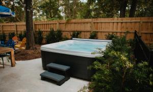 ein Whirlpool in einem Hof neben einem Holzzaun in der Unterkunft Luxury 6 Br Sleeps 18 Private Heated Pool Fire Pit in Hilton Head Island