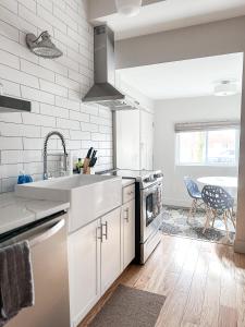 a kitchen with white cabinets and a sink and a table at The 4M Favorite House - Stunning & Spotless 2-Bed Apt (#1) in Ann Arbor