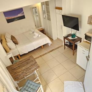 a small room with a bed and a television at כרמונ'ס פטיו - Carmona's Patio in Eilat