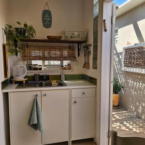 a small kitchen with a sink and a counter at כרמונ'ס פטיו - Carmona's Patio in Eilat +18 photos