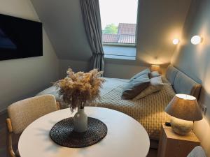 a small living room with a table and a bed at Nida & Sunrise *Self Check-In* in Nida