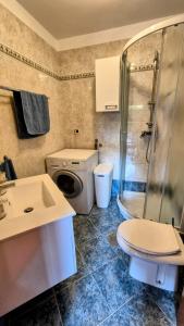 a bathroom with a sink and a washing machine at Hiska Calla, pocitniska hisa z razgledi, blizu Pirana in Sečovlje +33 photos