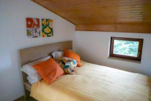 a bedroom with a bed with pillows and a window at Hiska Calla, pocitniska hisa z razgledi, blizu Pirana in Sečovlje