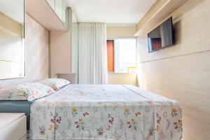 ブラジリアにあるBelíssimo de Alto Padrãoのベッドと壁掛けテレビのある寝室