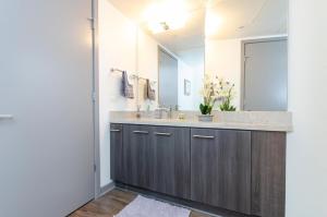 サンディエゴにあるModern 2BR Near Petco Park & Convention Centerの洗面台と大きな鏡のあるバスルーム +24枚の写真