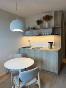 a kitchen with a table and chairs and a sink at Nida & Sunrise *Self Check-In* in Nida