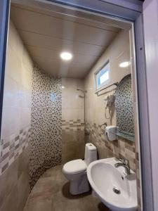 a bathroom with a toilet and a sink at Golden Horizon House in Kobuleti +33 photos