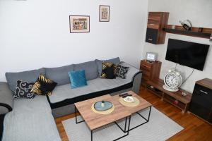 a living room with a couch and a coffee table at Apartman TEA Trebinje in Trebinje
