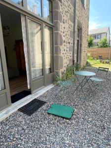 a green mat on the ground in front of a building at Maison Côté Halle La chambre de l'Artiste in Saint-Flour