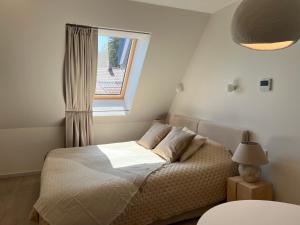 a bedroom with a bed and a window at Nida & Sunrise *Self Check-In* in Nida