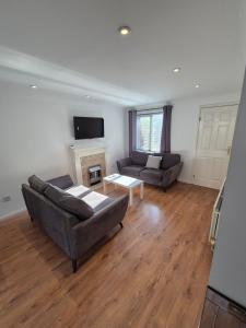 a living room with two couches and a fireplace at Bright & Cozy 3 Bed House with Parking in Northampton