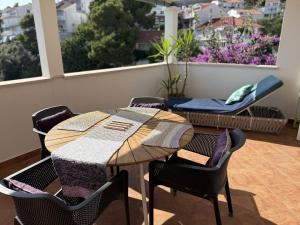 a wooden table and chairs on a patio with a balcony at Apartments Biba Hvar in Hvar