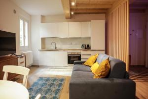 a living room with a couch and a kitchen at Good Vibes apartment centro storico Reggio Emilia in Reggio Emilia +17 photos