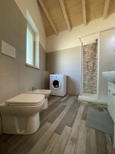 a bathroom with a toilet and a washing machine at Casa vacanze indipendente in Follonica