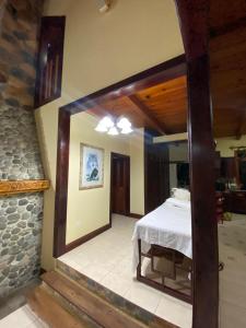 a bedroom with a bed and a stone wall at Casa Campestre Lomas de Holanda in Santa Cruz Verapaz