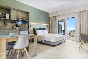 a bedroom with a bed and a desk with a view at Momento Suites in Vlachata