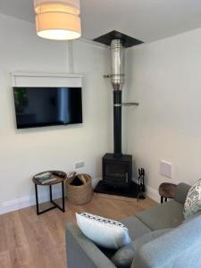 a living room with a couch and a fire place at Ancaire Lodge in Schull