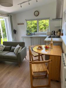 a kitchen and living room with a table and a couch at Ancaire Lodge in Schull