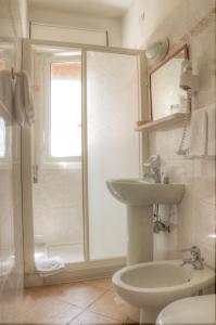 a bathroom with a toilet and a sink and a shower at Hotel Villa Lina in Loano