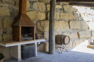 un mur de pierre avec un four et un tonneau dans l'établissement Oasis en el Montseny con piscina, jardín y natura, à Seva