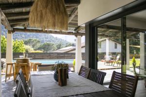 une salle à manger avec une table et des chaises et une grande fenêtre dans l'établissement Oasis en el Montseny con piscina, jardín y natura, à Seva