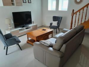 a living room with a couch and two chairs and a television at Villa Monica in Baud