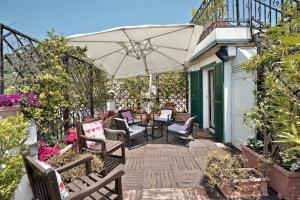 an outdoor patio with chairs and an umbrella at Hepburn Holiday Home in Salerno