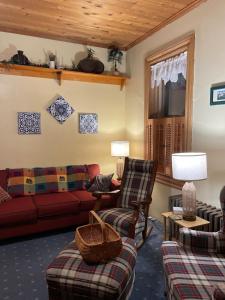 Una sala de estar con un sofá rojo y sillas. en Historic & Charming Home just Steps from Deer Creek Winery, en Uniontown