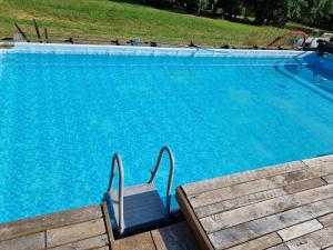 a blue swimming pool with a chair next to it at Chateau Le Plessis in Sémelay