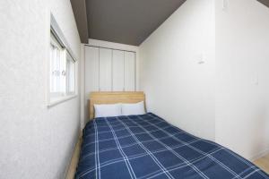 a bedroom with a blue bed in a white room at Meteore Kotoni - Vacation STAY 19035 in Sapporo