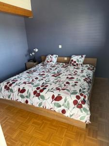 a bed with a floral comforter in a bedroom at BnB la Vague in Port-Valais