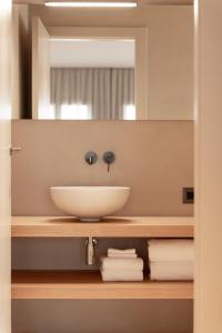un bagno con lavandino e specchio di Alma Suites a Lido di Jesolo Altre 18 foto