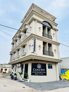 a tall white building with a sign on it at Hotel Casa Inn in Indore +69 photos