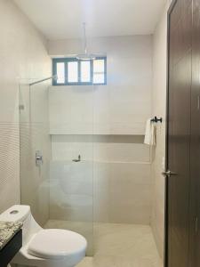 a bathroom with a toilet and a glass shower at Comfortable Modern Stays provided by Hidden Gem Vacation Homes in Zapotlanejo
