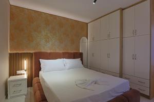 a bedroom with a large bed with white cabinets at Mato Luxury Apartments 3 in Sarandë