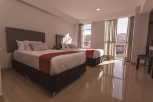 Postel nebo postele na pokoji v ubytování Sumaq Cusco Suites