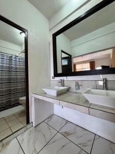 a bathroom with two sinks and a mirror at Hotel Mercy in San Juan La Laguna