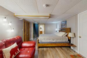 a bedroom with a bed and a leather couch at Perfect Mountain Location in North Conway