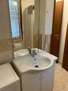 a bathroom with a white sink and a mirror at Sweet Room MARY in Santa Maria Maddalena
