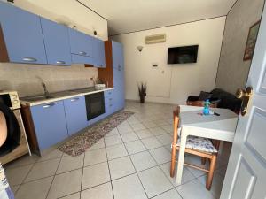 a kitchen with blue cabinets and a table and a couch at Sweet Room MARY in Santa Maria Maddalena +4 photos