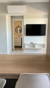 a living room with a flat screen tv on a wall at Apartamento completo – perto do centro de Bauru in Bauru
