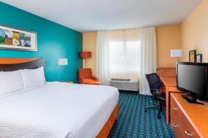 a hotel room with a bed and a flat screen tv at Fairfield Inn & Suites Kansas City Lee's Summit in Lees Summit