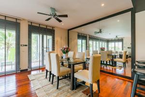 Un comedor con mesa y sillas en 3BR Casa Blanc - Beachfront Home in Laguna & Layan Chom Tawan and Maan Tawan Residences, en Phuket