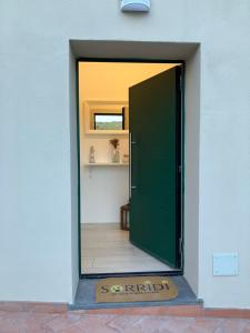 a green door with a sign in front of a building at A due passi da Sansone in Portoferraio