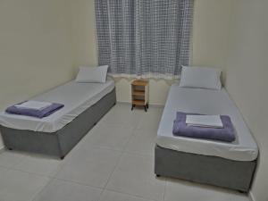 two beds in a room with a window at Apartamento da Dani in Guaratinguetá